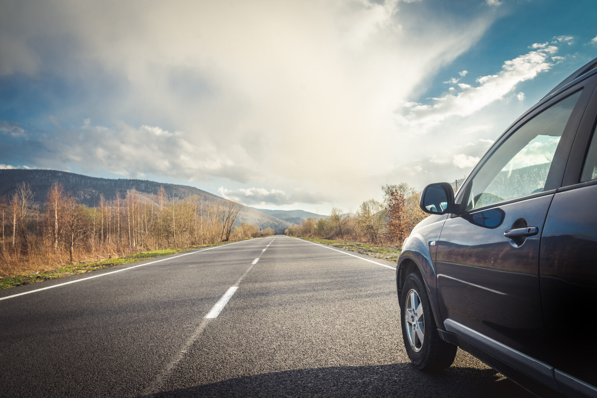 car for traveling with a mountain road. Blue sky