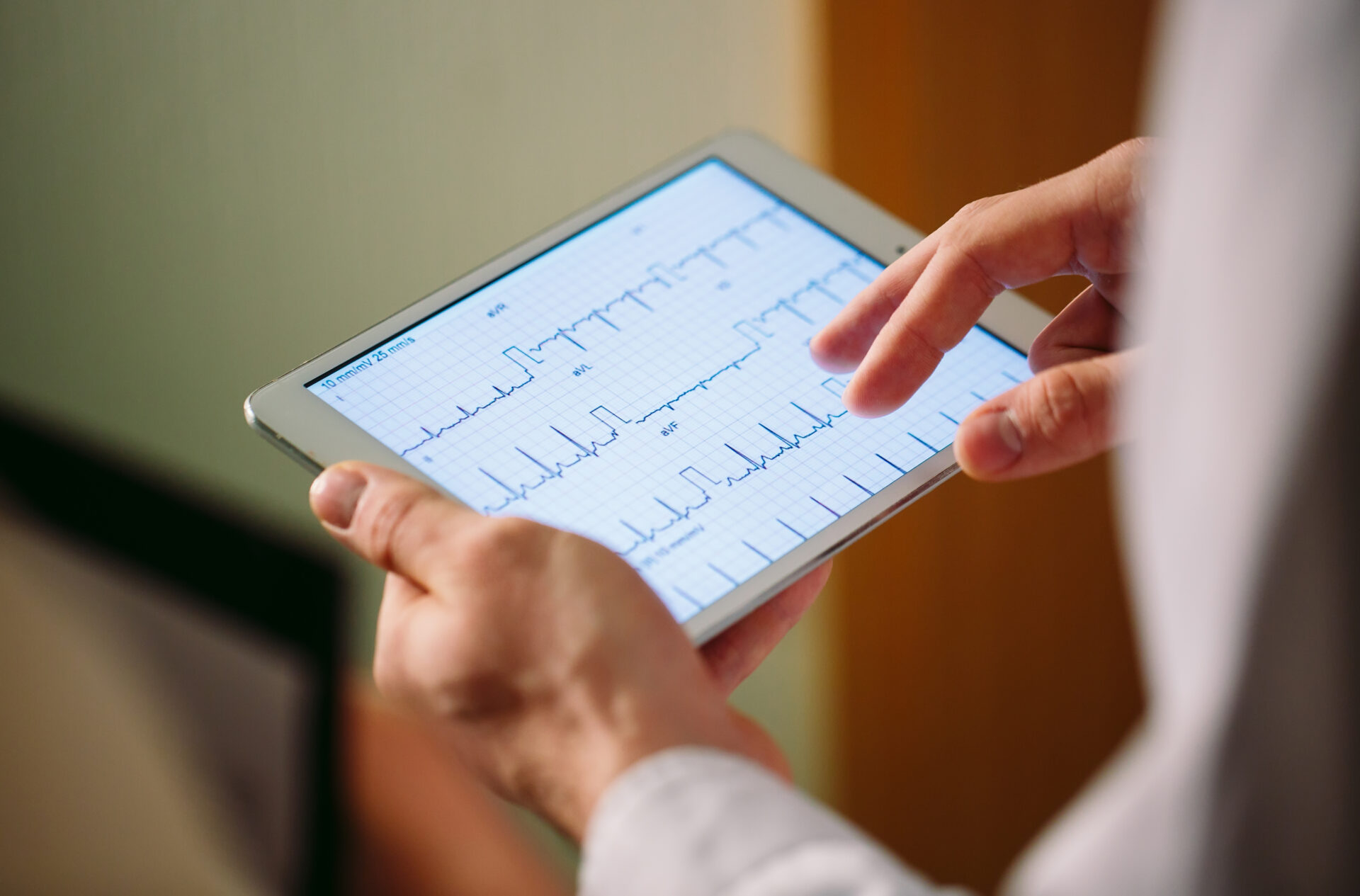 Doctors discussing patient's cardiogram on the tablet.