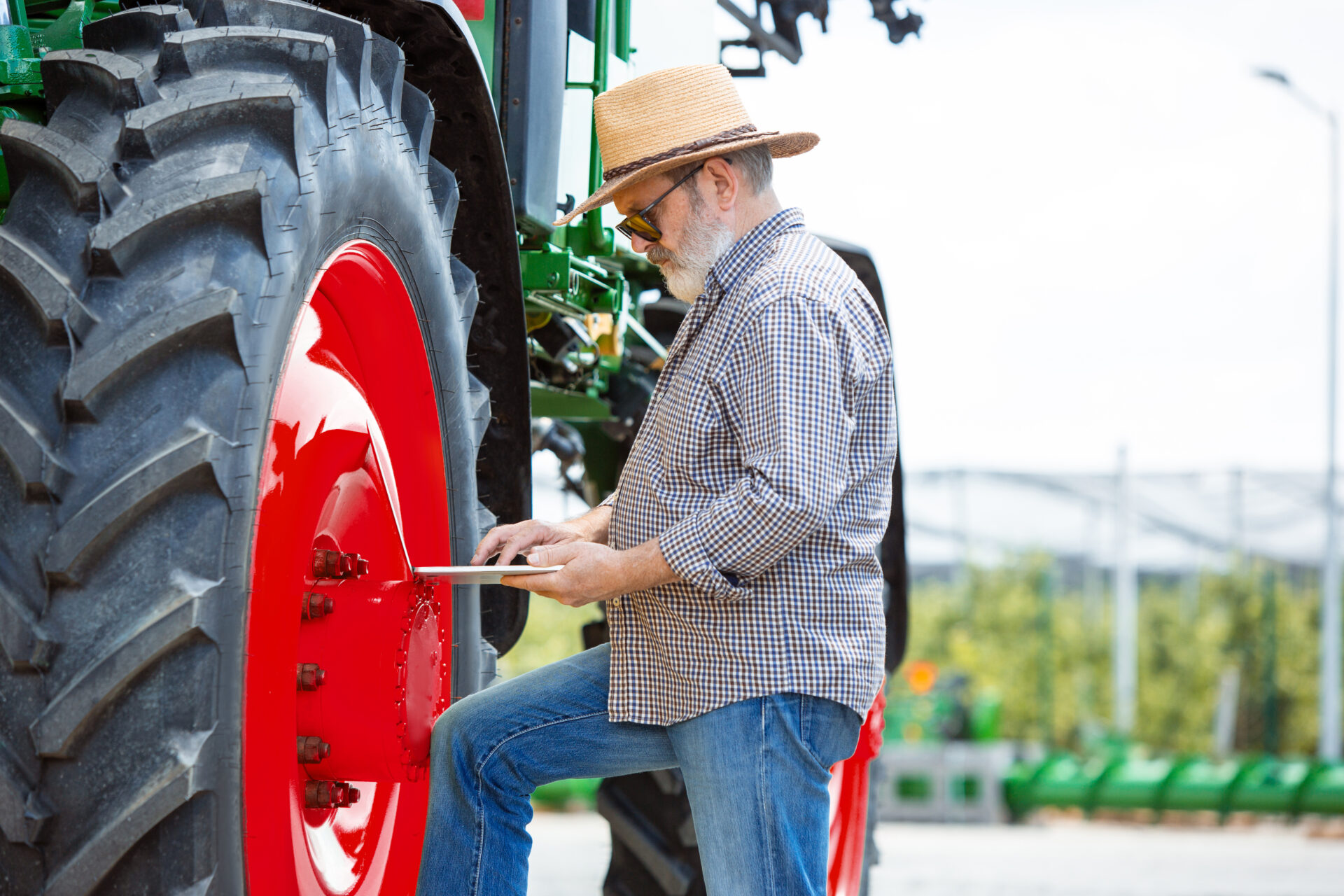 A farmer with a tractor, combine at a field in sunlight. Confident, bright colors