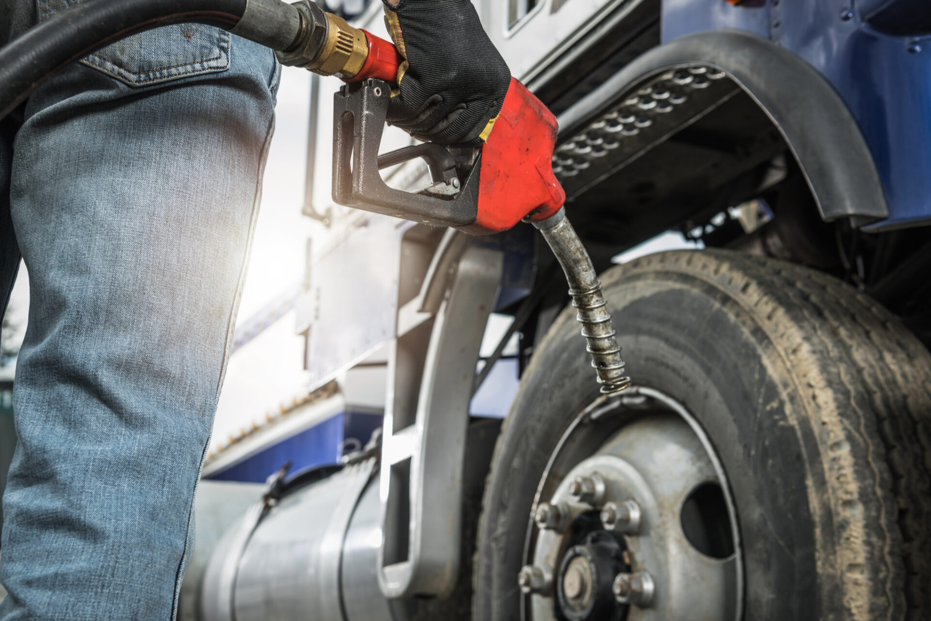 Aged Semi Truck Driver About to Refuel His Tractor Truck Holding Diesel Pump Nozzle in His Hand. Heavy Duty Transportation and Fuel Shortage Concept.