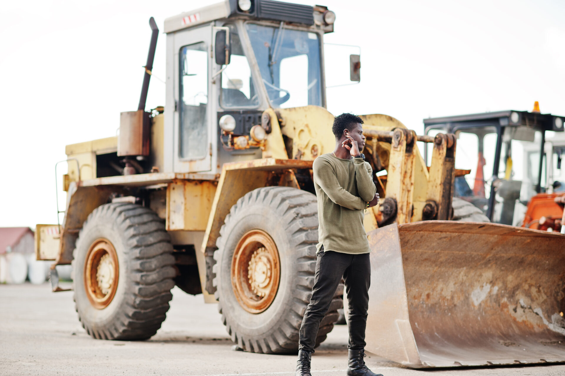 Portrait of an attractive black african american man posing next to the industrial machinery.