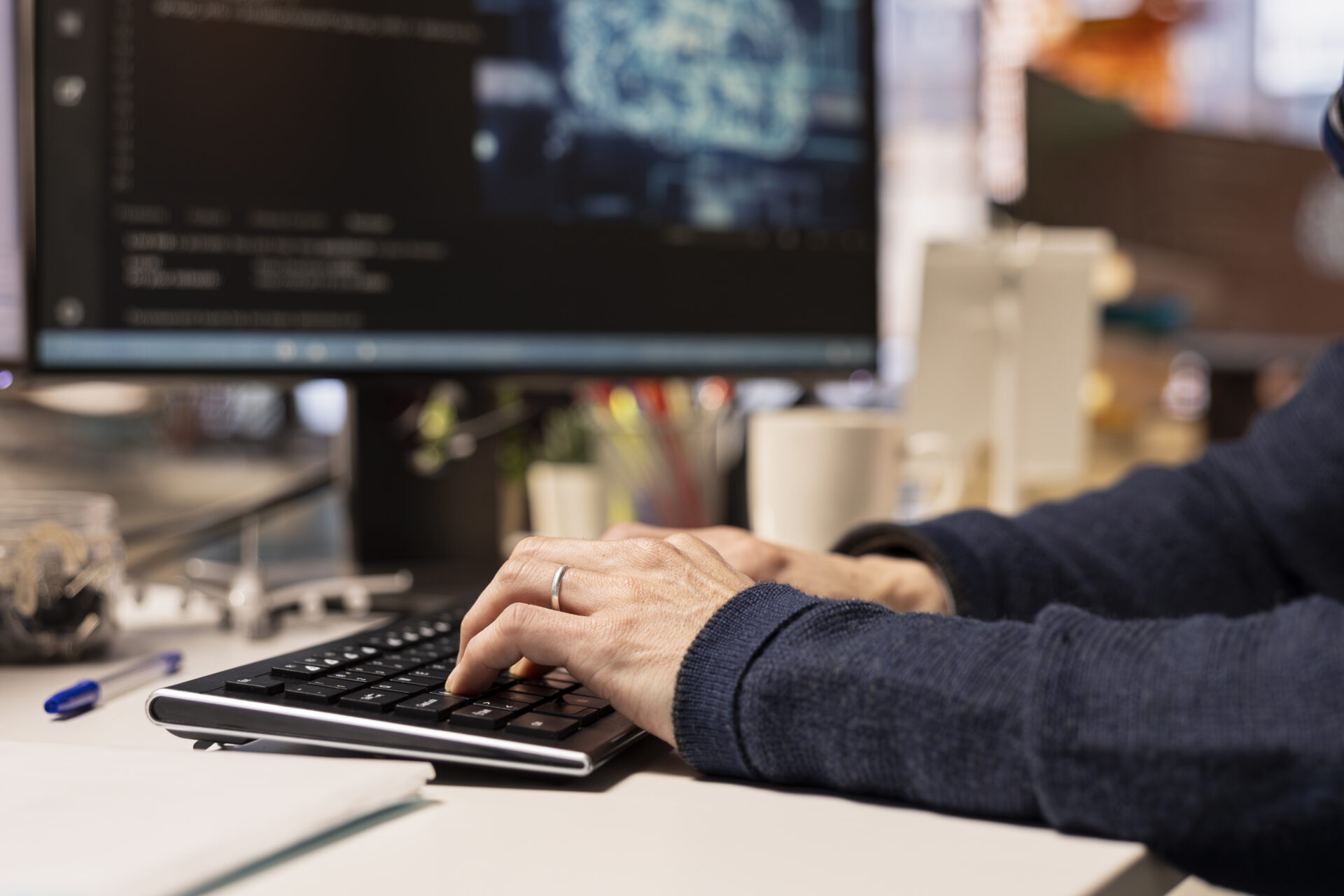 Startup programmer leveraging artificial intelligence tech in office to gain competitive edge. Close up of AI specialist typing on PC keyboard, working on rapid technological advancement