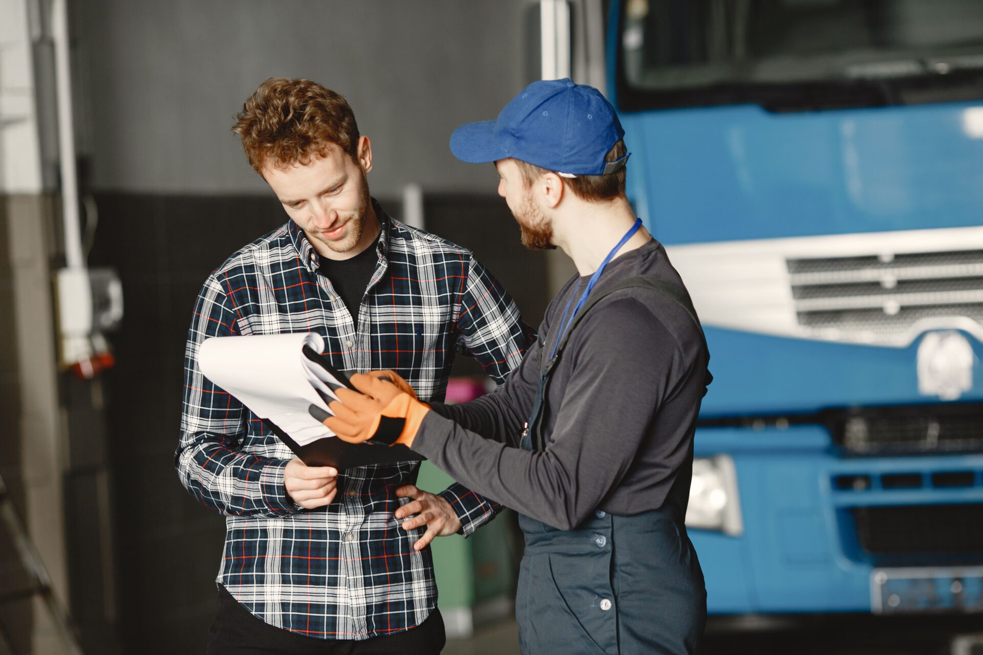 https://escortsensors.com/wp-content/uploads/2026/03/two-guys-talking-about-work-work-garage-near-truck-transfer-documents-with-goods.jpg